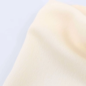 Close-up of premium cream-colored knit fabric showing detailed texture and soft weave
