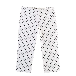 Flat lay of vintage white trousers with black polka dots featuring straight leg cut