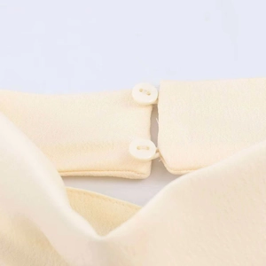 Women's sexy halter top in cream yellow with asymmetric neck and dual button detail