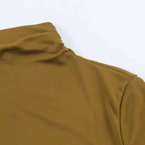 Detail of mustard yellow high-neck dress showing fine mesh texture and seam craftsmanship