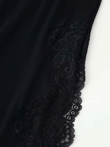 Close-up of intricate black floral lace trim on the hem of a sexy summer dress