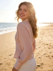 Détail d'une chemise d'été rose pâle en lin avec boutons délicats sur une plage au coucher
