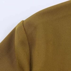 Detailed macro view of mustard yellow knit fabric with premium texture and shoulder seam