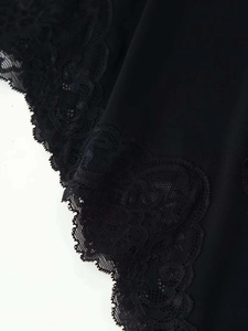 Detailed view of intricate black lace trim and smooth fabric on a sexy summer dress