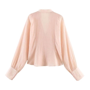 Vue détaillée du dos d'un chemisier en crêpe rose clair avec col V et poignets boutonnés