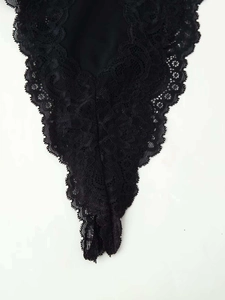 Close-up of black floral lace fabric with intricate wave-cut edges and delicate texture