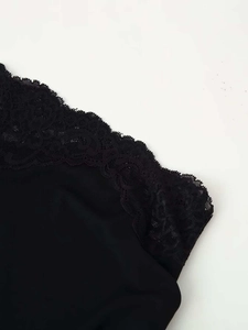 Close-up detail of delicate floral lace trim on a black summer dress with soft fabric