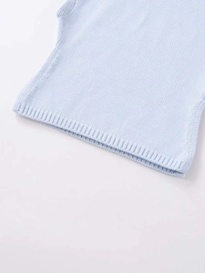 Detailed close-up of light blue knitted vest fabric texture and ribbed hem finish