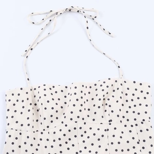 Detail showing cream halter neck top with black polka dots and adjustable tie strap