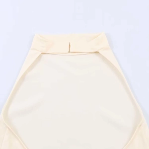 Detailed close-up of cream halter neck top with textured fabric and fine collar stitching