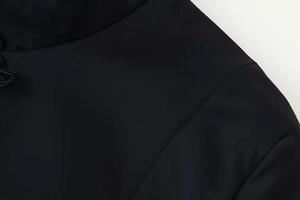 Detail of mandarin collar and button clasp on the black minimalist women's waist jacket
