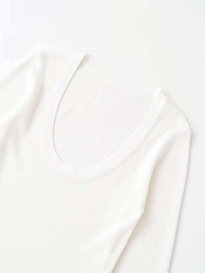 Close-up of the deep U-neckline and fine knit texture of this white long sleeve top