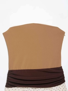 Detailansicht von gerafftem braunem Stoff und schwarzem Punktmuster auf dem Kleid