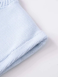 Detailed macro view of light blue knitted fabric with premium ribbed texture and neat hem