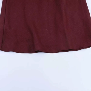 Detailed macro view of the wine red midi dress hem with professional rolled edge stitching