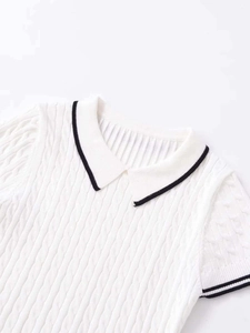 Detail of white cable knit polo shirt featuring black contrast stripe on the collar