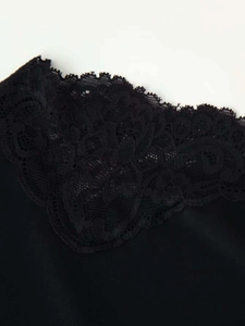 Detail of delicate black lace embroidery and silky fabric on this summer dress