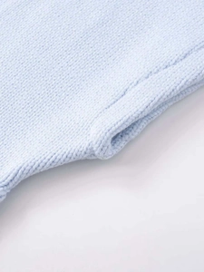 Close-up of light blue knitted vest showing fine texture and hemline details