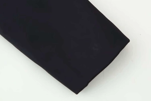 Close-up detail of smooth matte black textile fabric on jacket sleeve or hemline