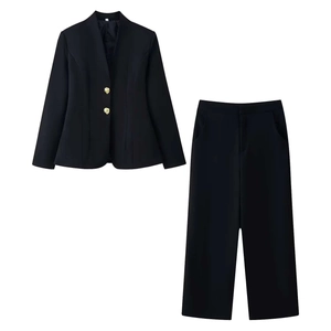 Flat lay of women's black business suit with elegant golden buttons on the blazer