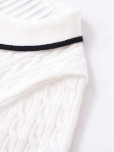 Close-up of white cable knit short sleeve sweater with a black stripe on the ribbed neckline