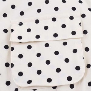 Detailed macro view of the polka dot fabric and flap pocket on a vintage summer blouse