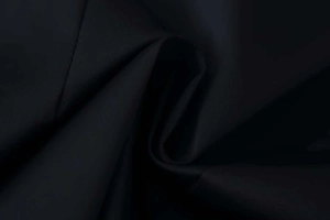 Close-up detail of high-quality black woven fabric with elegant texture and soft drape