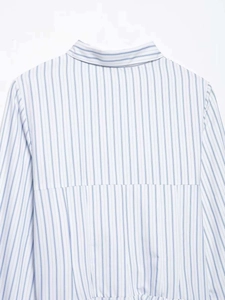 Detail of blue and white vertical striped shirt dress showing back yoke and pleated fabric