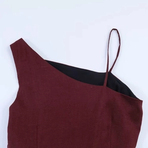 Detail of burgundy asymmetrical neckline showing textured fabric and quality stitching