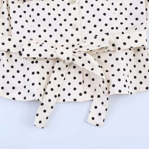 Detail of vintage polka dot shirt showing button closure and waist tie with bow