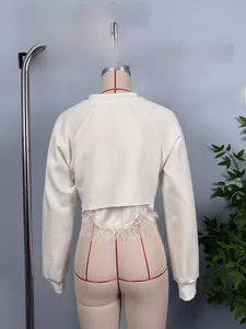 Detailed back view of white long sleeve sweatshirt with delicate lace trim at hem