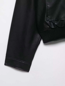Détail de l'ourlet côtelé et des coutures de poche sur une veste en cuir noir chic