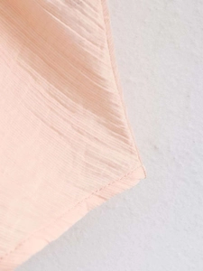 Gros plan sur le tissu plissé rose montrant la texture fine et les coutures propres