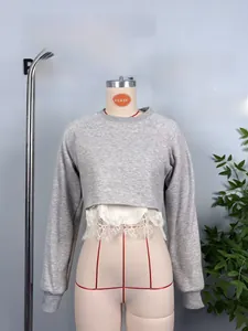 Detail view of grey cropped sweatshirt featuring white eyelash lace trim at the bottom hem