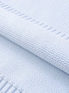 Close-up of light blue knitted fabric texture with decorative striped weave patterns
