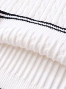 Detailed macro view of white cable knit fabric with contrasting black stripes
