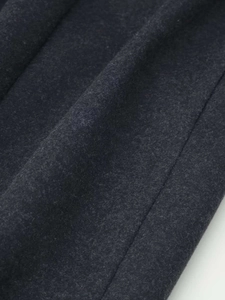 Close-up of charcoal grey wool blend fabric showing rich fiber texture and stitching
