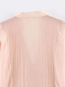 Détail du col de chemise rose clair et coupe d'épaule avec tissu à texture plissée