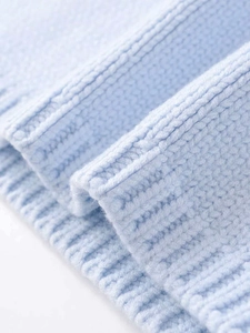 Close-up of light blue knit fabric showing ribbed cuffs and soft plush texture