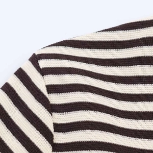 Close-up of brown and white striped knit fabric showing fine stitching on the shoulder seam