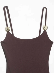 Detail of coffee brown bodysuit featuring gold spiral metal buckle on shoulder straps