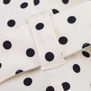 Macro detail of polka dot twill fabric with neat stitching and a belt loop detail
