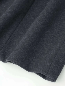 Detail of dark charcoal wool fabric texture with clean stitched hem and fine fibers