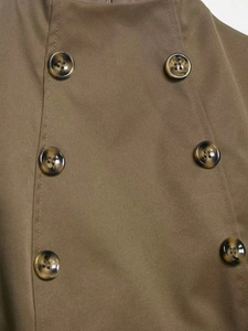 Close-up of double-breasted brown twill vest featuring classic tortoiseshell buttons