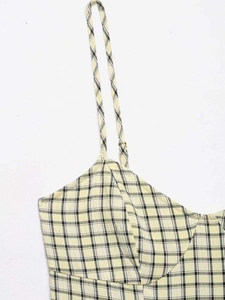 Detail des gelb-schwarz karierten Midikleids mit dünnen Trägern und feiner Stoffstruktur