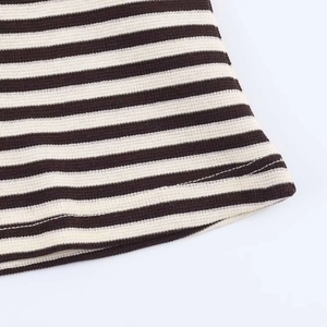 Close-up of brown and white striped knit fabric with precise hem stitching detail