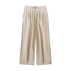Detail view of champagne satin wide-leg trousers with sharp central pleats and high-waist