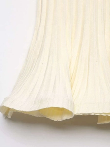 Gros plan détaillé du tricot côtelé beige montrant l'ourlet volanté et la texture