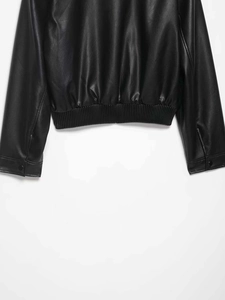 Gros plan d'une veste en cuir noir avec ourlet côtelé et boutons-pression aux poignets