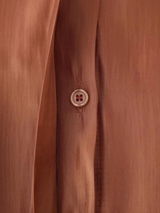 Close-up of caramel tencel shirt buttons showing premium twill fabric and silky texture